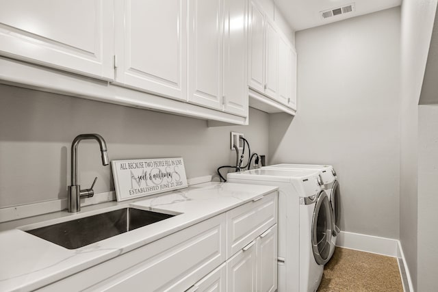 laundry room featuring independent washer and dryer, a sink, visible vents, baseboards, and cabinet space