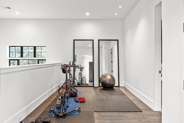exercise area featuring recessed lighting, visible vents, wood finished floors, and baseboards