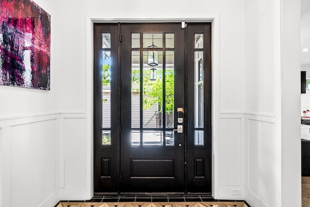foyer featuring a wainscoted wall and a decorative wall