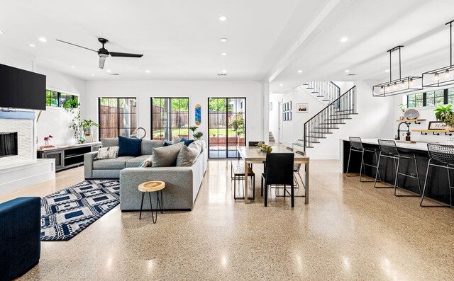 living area with recessed lighting, a ceiling fan, a wealth of natural light, and a fireplace