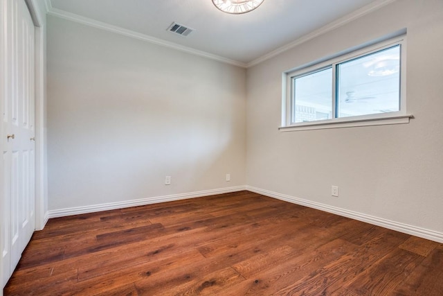 unfurnished room with baseboards, visible vents, ornamental molding, and dark wood-type flooring