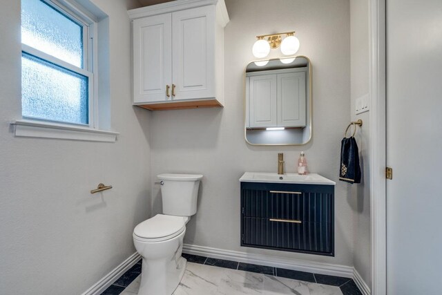 bathroom with baseboards, toilet, and vanity