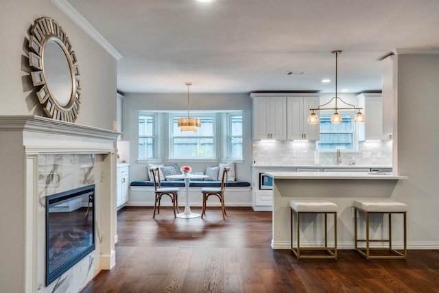 kitchen featuring decorative backsplash, a sink, visible vents, light countertops, and dark wood-style floors