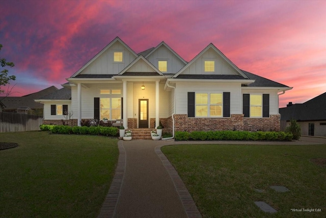 craftsman-style home featuring a front lawn, brick siding, board and batten siding, and fence