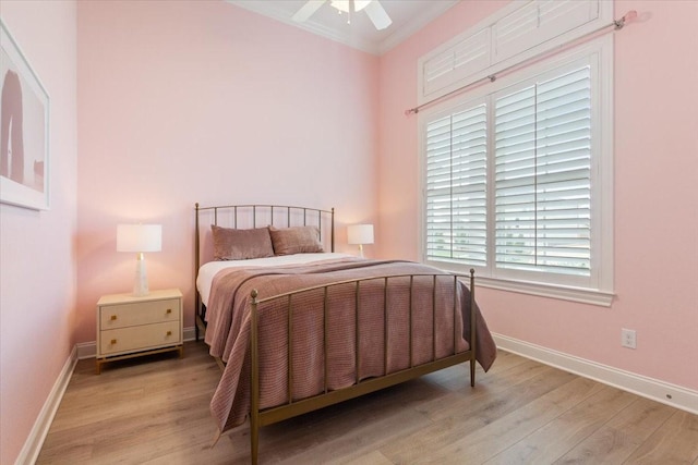 bedroom featuring ornamental molding, light wood finished floors, a ceiling fan, and baseboards