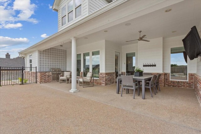 view of patio featuring fence, outdoor dining space, grilling area, and a ceiling fan