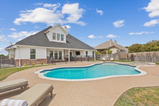 view of swimming pool with a patio, a fenced backyard, and a pool with connected hot tub