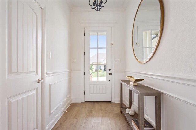 entryway with light wood-type flooring and ornamental molding
