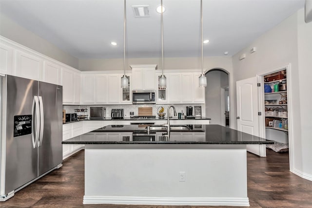 1116 Quail Dove Dr, Little Elm, TX 75068 - kitchen featuring appliances with stainless steel finishes, arched walkways, a kitchen island with sink, backsplash, and recessed lighting