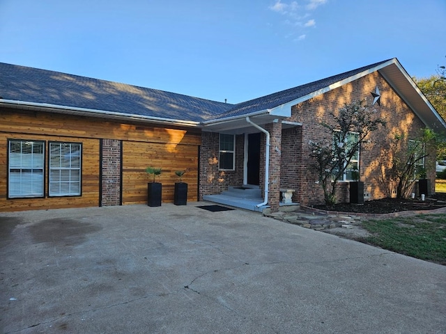 exterior space with brick siding, driveway, and a garage