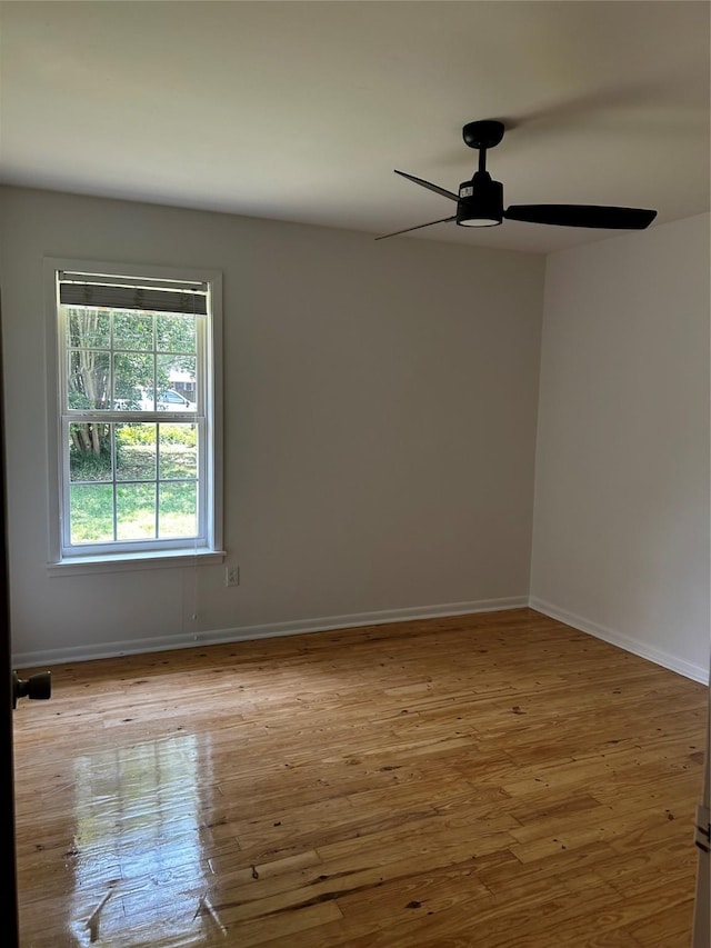 empty room featuring baseboards, a ceiling fan, and wood finished floors