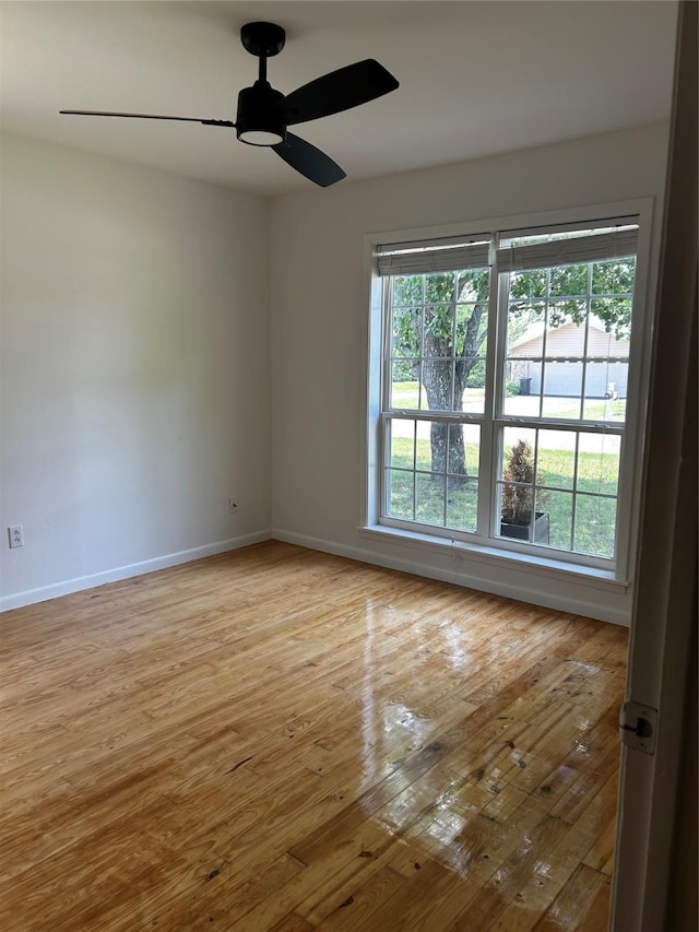 unfurnished room featuring baseboards, ceiling fan, and hardwood / wood-style floors