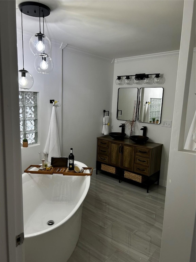 full bathroom featuring a sink, double vanity, a freestanding tub, and ornamental molding