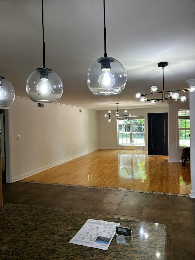 interior space with decorative light fixtures, baseboards, a chandelier, and tile patterned flooring