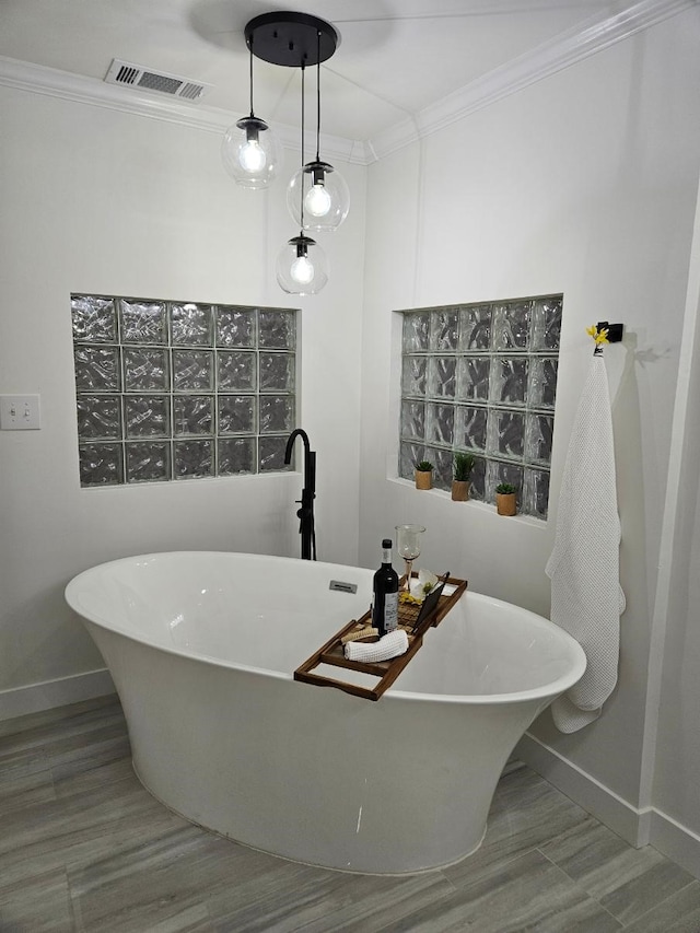 bathroom featuring baseboards, ornamental molding, wood finished floors, and visible vents