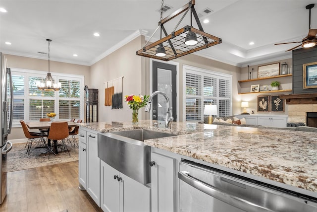 kitchen featuring a sink, stainless steel appliances, visible vents, light wood-style flooring, and ornamental molding