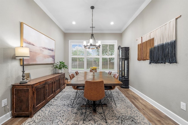 dining room with baseboards, an inviting chandelier, light wood-style floors, and crown molding