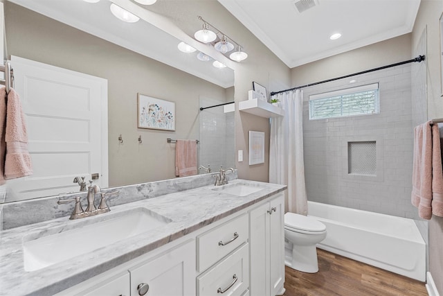 bathroom with visible vents, wood finished floors, crown molding, and a sink