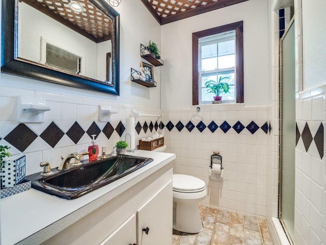 full bath with toilet, a wainscoted wall, a shower stall, and tile walls