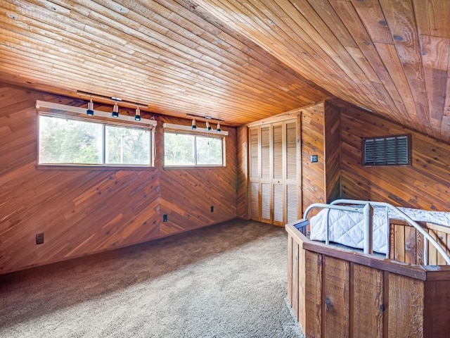 interior space with wooden walls, lofted ceiling, carpet floors, and wood ceiling
