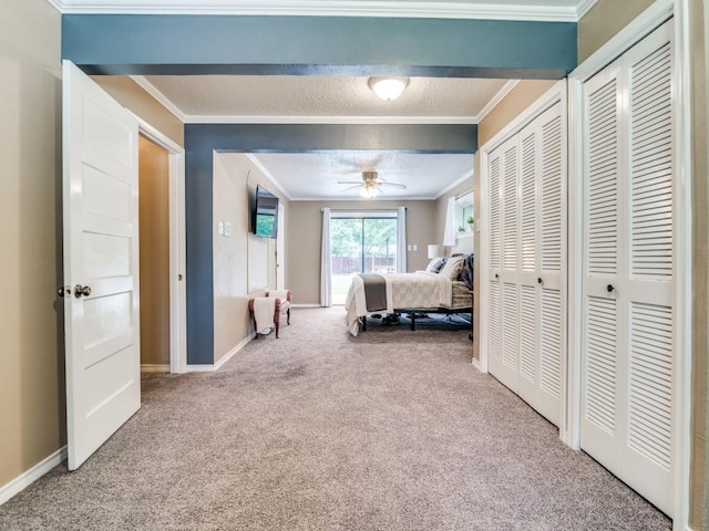 carpeted bedroom featuring ornamental molding, a textured ceiling, and baseboards