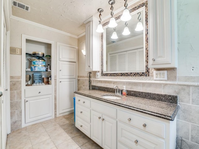 bathroom featuring crown molding, tile walls, visible vents, and vanity