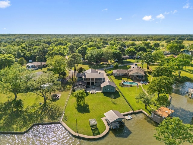 drone / aerial view with a wooded view and a water view