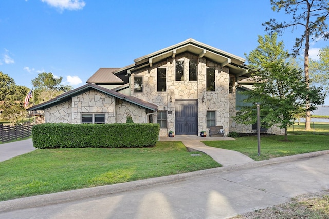 view of front facade with fence, a front yard, and stone siding