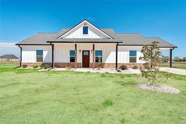 view of front facade featuring board and batten siding, a shingled roof, and a front lawn