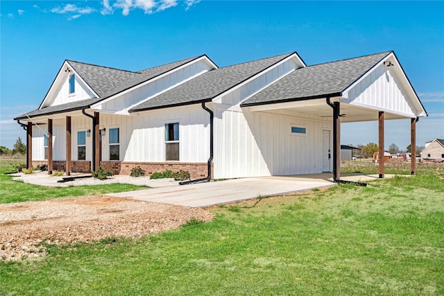 exterior space featuring a yard, an attached carport, a shingled roof, and concrete driveway