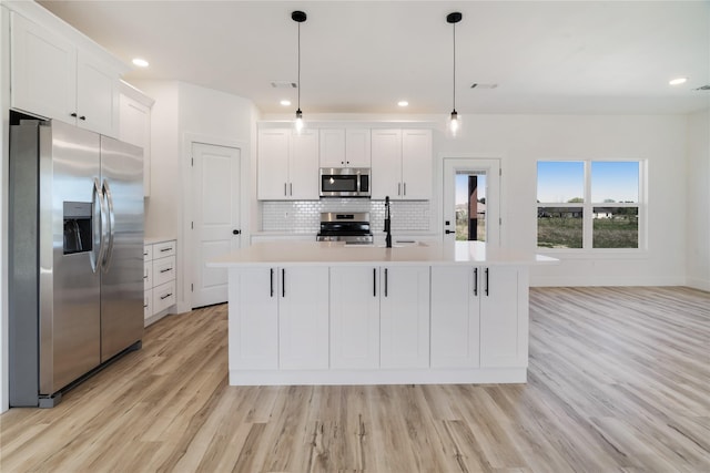 kitchen featuring stainless steel appliances, light wood-style floors, tasteful backsplash, white cabinetry, and light countertops