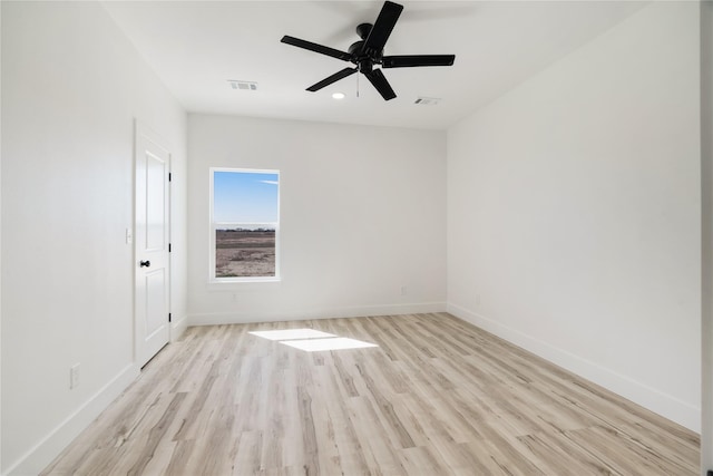 unfurnished room with wood finished floors, ceiling fan, visible vents, and baseboards