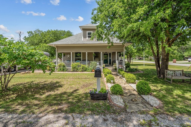 view of front of home featuring covered porch, a shingled roof, and a front yard