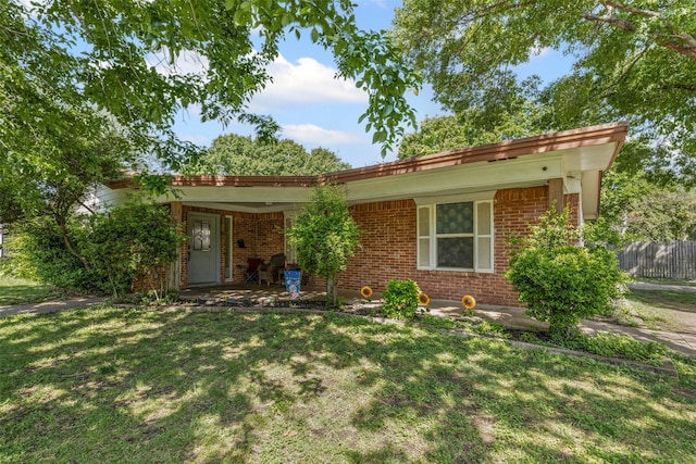 view of front of home featuring brick siding and a front yard