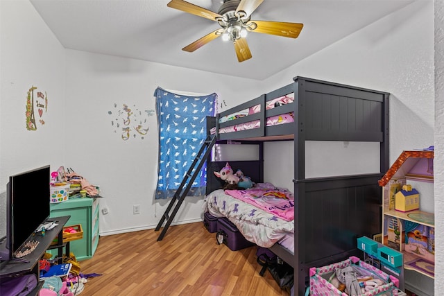 bedroom with baseboards, wood finished floors, and a ceiling fan