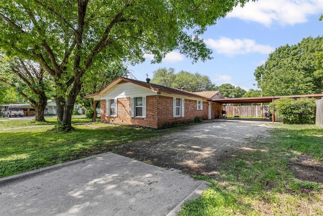 ranch-style home with driveway, a front lawn, and brick siding