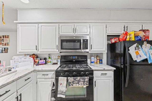 kitchen with black appliances, light stone counters, and white cabinets