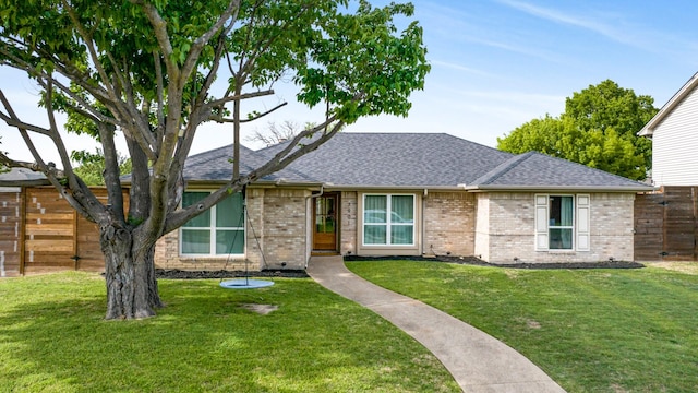 single story home featuring brick siding, fence, a front lawn, and roof with shingles