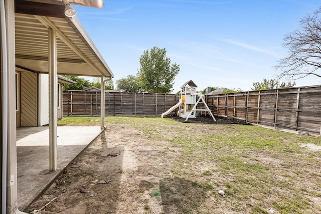 view of yard with a fenced backyard, a patio area, and a playground