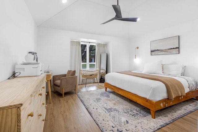 bedroom with ceiling fan, light wood-style flooring, and vaulted ceiling