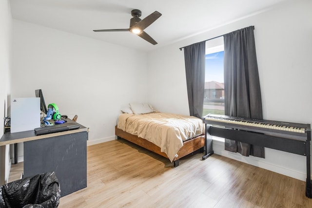 bedroom featuring ceiling fan, light wood finished floors, and baseboards