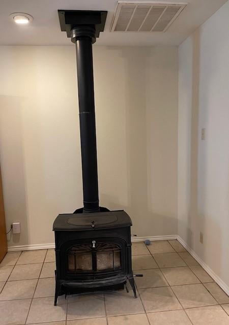 interior details with baseboards, a wood stove, and visible vents