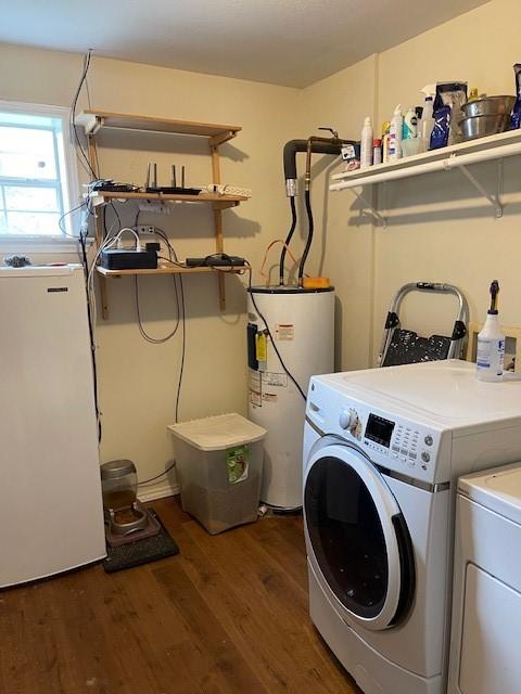 washroom with wood finished floors, laundry area, washing machine and dryer, and electric water heater