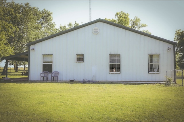 rear view of house featuring a lawn and board and batten siding