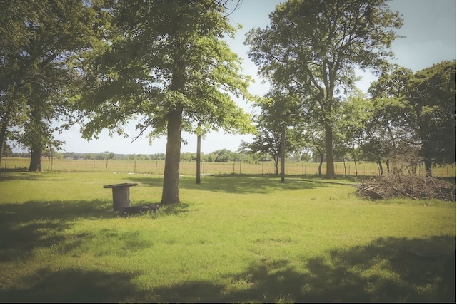 view of yard with a rural view and fence