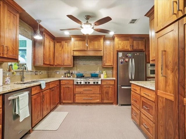 1428 Oxford Ln, Denton, TX 76209 - kitchen with visible vents, brown cabinetry, a sink, appliances with stainless steel finishes, and backsplash