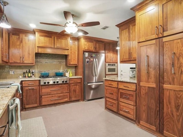 1428 Oxford Ln, Denton, TX 76209 - kitchen with a ceiling fan, appliances with stainless steel finishes, brown cabinetry, and visible vents