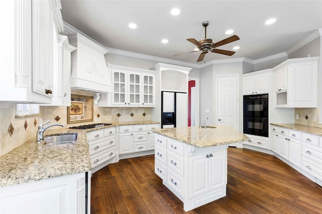 kitchen with dobule oven black, a ceiling fan, white cabinets, and a sink