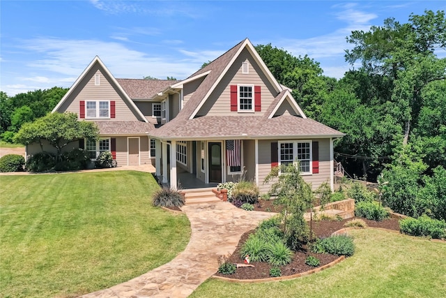 craftsman-style house featuring roof with shingles, a porch, and a front yard