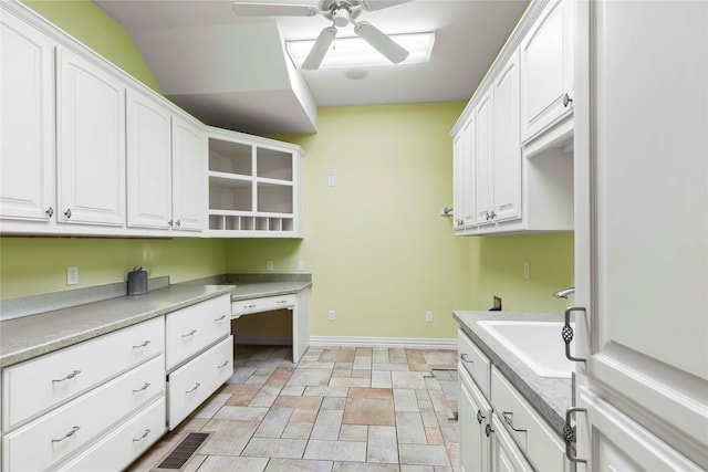 washroom featuring stone finish floor, a sink, visible vents, baseboards, and a ceiling fan